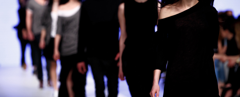 women walking down a runway wearing different black ensembles fashion