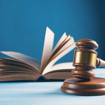 A gavel and law book on a blue background