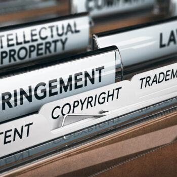 A filing cabinet drawer with file tabs labeled "INTELLECTUAL PROPERTY," "INFRINGEMENT," "COPYRIGHT," and "TRADEMARK."
