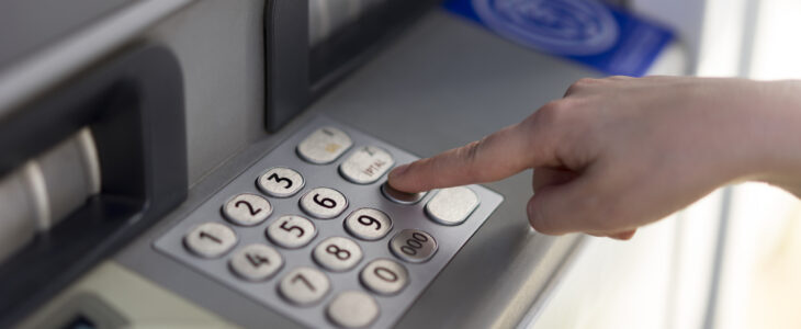 Person pressing a button on an ATM keypad