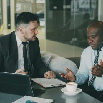 Two business men arguing while looking at a laptop