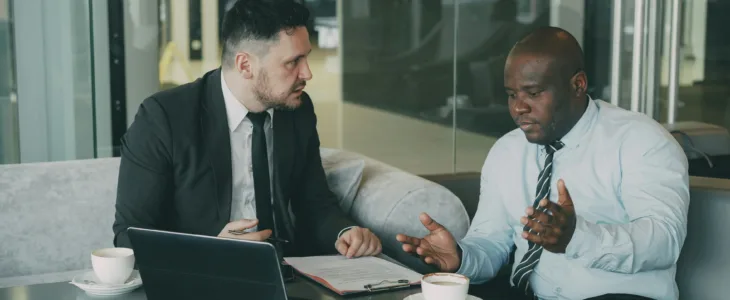 Two business men arguing while looking at a laptop