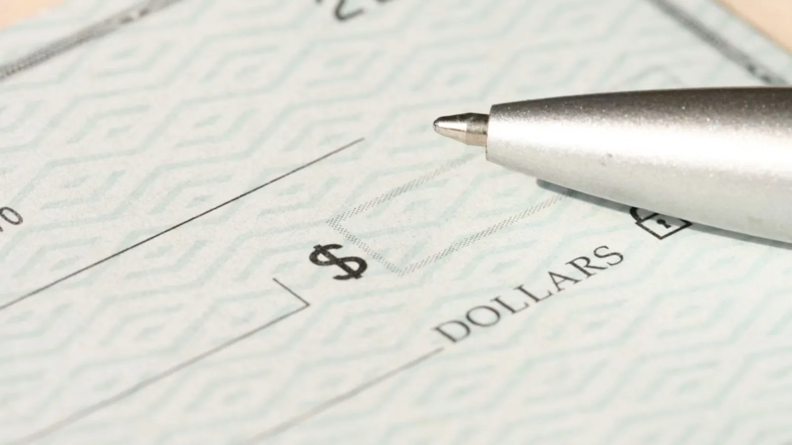 A closeup of a pen laying on a blank check