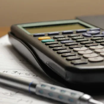A scientific calculator sitting on a stack of paperwork
