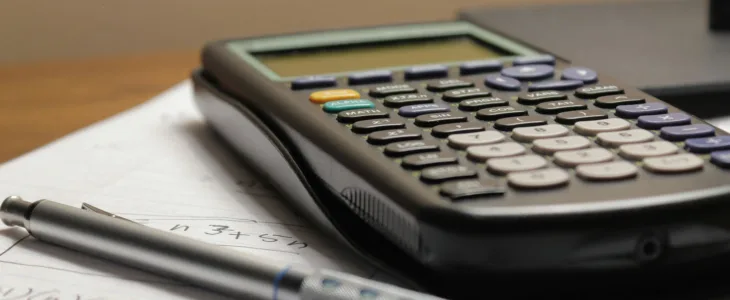 A scientific calculator sitting on a stack of paperwork