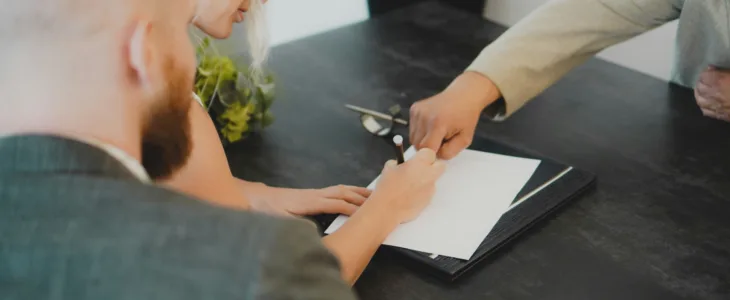 A man showing someone where to sign on a contract