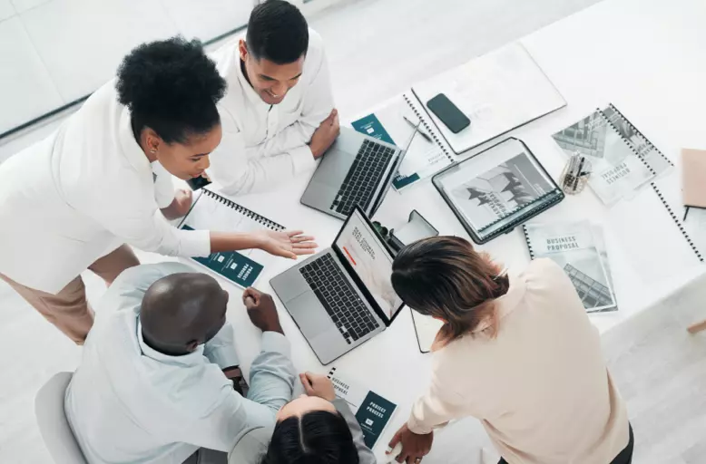 An overhead shot of a diverse group of people collaborating around a conference table.