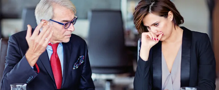 Two people discussing documents at a table.