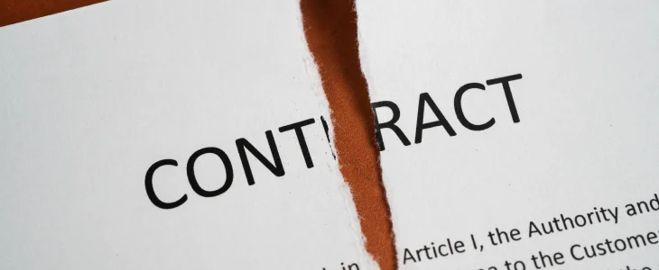 A close-up of a contract being torn in half.